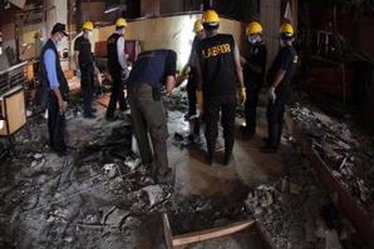 Petugas Pusat Laboratorium Forensik Mabes Polri melakukan olah TKP di titik ledakan bom di Hotel Ritz-Carlton, Jakarta Selatan, Sabtu (18/7).