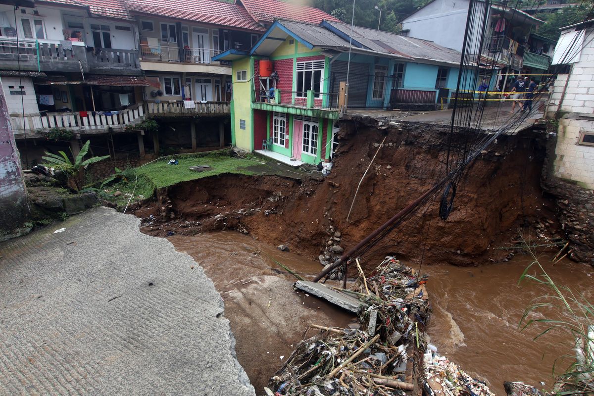 Jembatan dan jalan terputus akibat diterjang banjir bandang di Kampung Pensiunan, Desa Tugu Selatan, Cisarua, Kabupaten Bogor, Jawa Barat, Senin (3/3/2025). BPBD Kabupaten Bogor, Jawa Barat mencatat sebanyak 423 jiwa di Kampung Pensiunan tersebut terdampak bencana banjir akibat luapan Sungai Ciliwung.