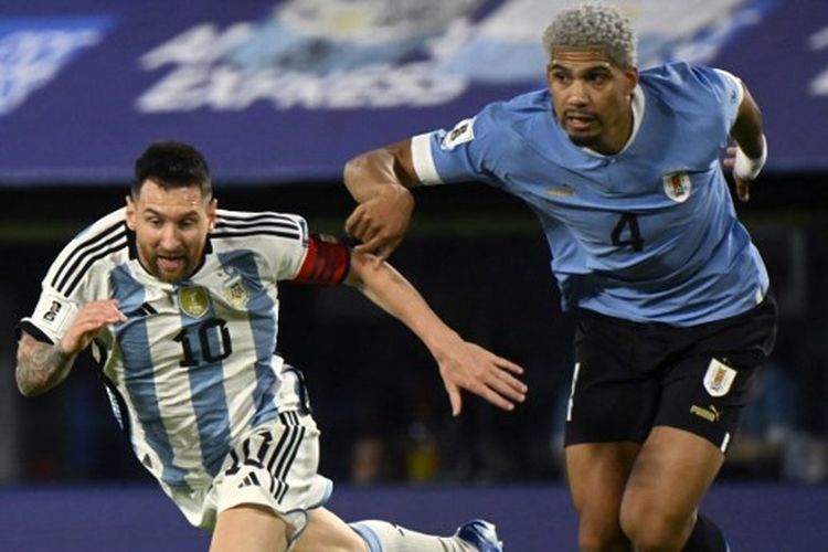 Bek Uruguay, Ronald Araujo, melakukan pelanggaran kepada penyerang Argentina, Lionel Messi, dalam Kualifikasi Piala Dunia 2026 Zona Amerika Selatan yang mempertemukan Argentina vs Uruguay di Stadion Bombonera pada 16 November 2023. (Photo by Luis ROBAYO / AFP)