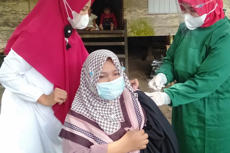 Khairani (50) Warga Desa Bueng Bak Jok melakukan vaksinasi program door to door, sebelumnya dijadwalkan Presiden Joko Widodo berkunjung ke desa ini, tapi kunjungan tersebut Batal.