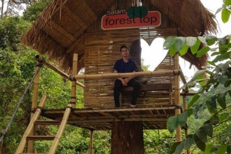 Ilustrasi pengunjung duduk di spot foto Batam Forest Top