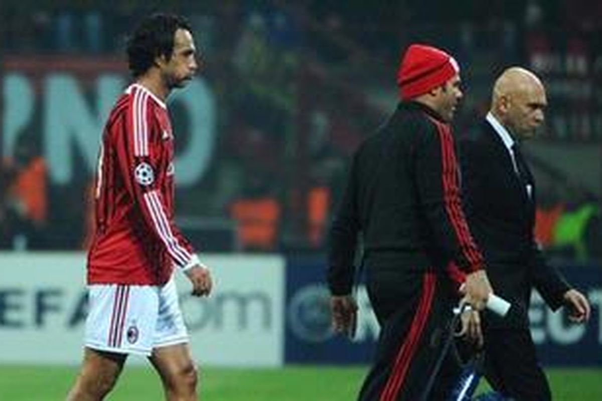 Defender AC Milan, Alessandro Nesta (kiri), harus keluar dari lapangan saat timnya melawan Barcelona di Liga Champions, Rabu (23/11/2011). Dia cedera otot paha dan harus absen sampai akhir tahun.