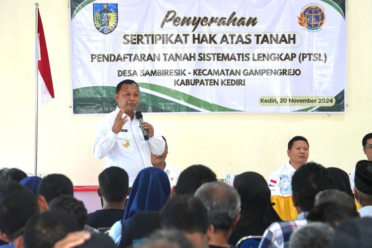 Pjs Bupati Kediri Heru Wahono Santoso saat membagikan sertifikat PTSL di Desa Sambiresik, Kecamatan Gampangrejo, Kabupaten Kediri, Rabu (20/11/2024).