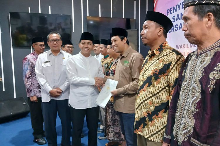 Wakil Menteri ATR/BPN Raja Juli Antoni (tengah) saat menyerahkan sertifikat tanah wakaf secara simbolis kepada para penerima di kantor BPN Gresik, Jawa Timur, Rabu (27/3/2024).