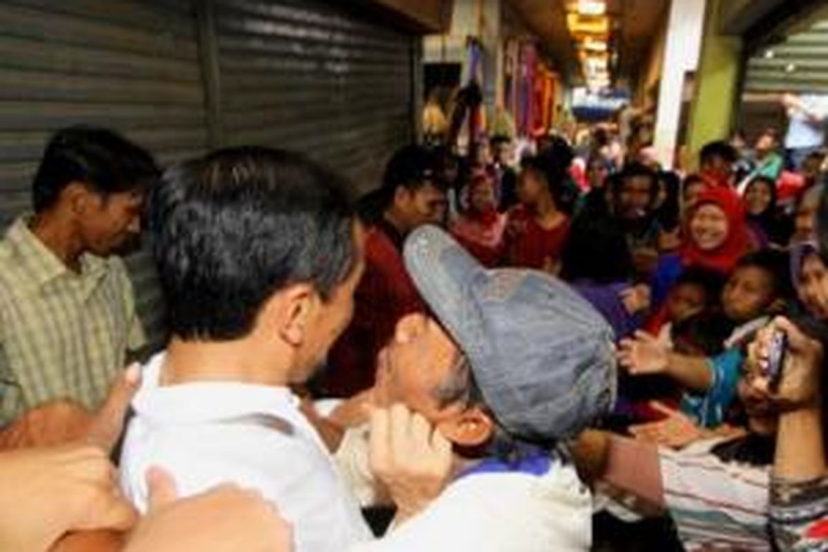 Calon presiden dari PDI Perjuangan Joko Widodo hendak dicium warga di Pasar Kota Gajah, Lampung Tengah, saat blusukan ke tempat tersebut, Sabtu (22/3/2014) siang. 