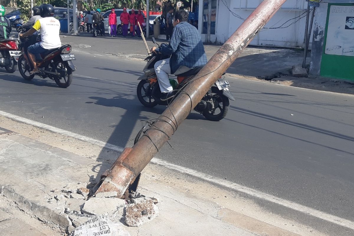 Keadaan besi tiang listrik yang roboh dan bagian bawahnya terlepas dari Jalan Raya Kebon Jeruk, Senin (21/10/2019).