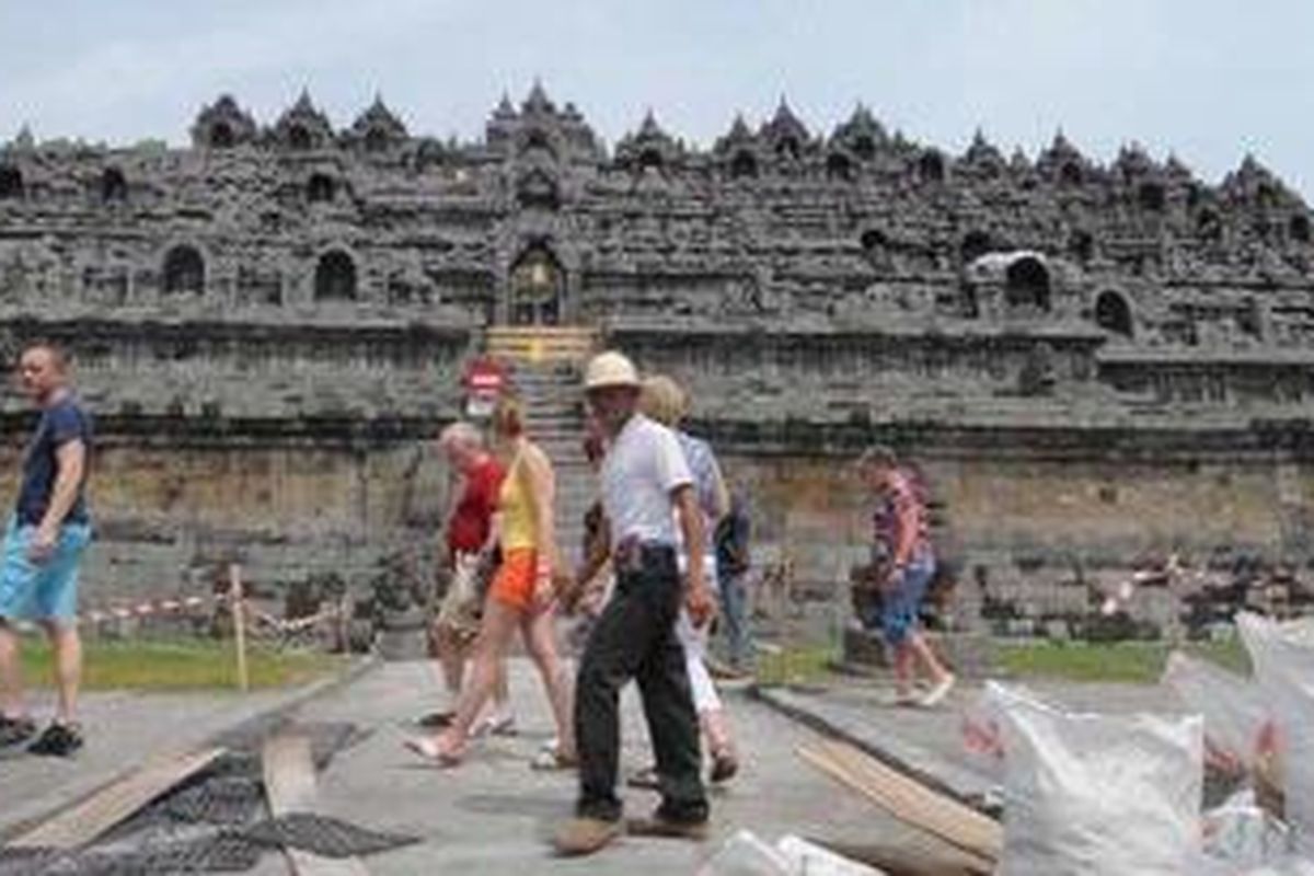 Wisatawan asing mengunjungi Candi Borobudur, Kabupaten Magelang, Jawa Tengah, Minggu (28/11/2010). Aktivitas pariwisata di Candi Borobudur sempat tutup akibat abu dan pasir vulkanik Gunung Merapi menutupi badan Candi. Walau telah kembali dibuka, pengunjung hanya bisa sampai pelataran (zona I) karena masih ada proses pembersihan candi. 
