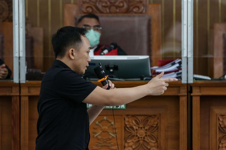 Terdakwa kasus pembunuhan berencana Brigadir J atau Nofriansyah Yosua Hutabarat, Ricky Rizal memeragakan adegan penembakan saat menjalani persidangan di Pengadilan Negeri Jakarta Selatan, Senin (9/1/2022).