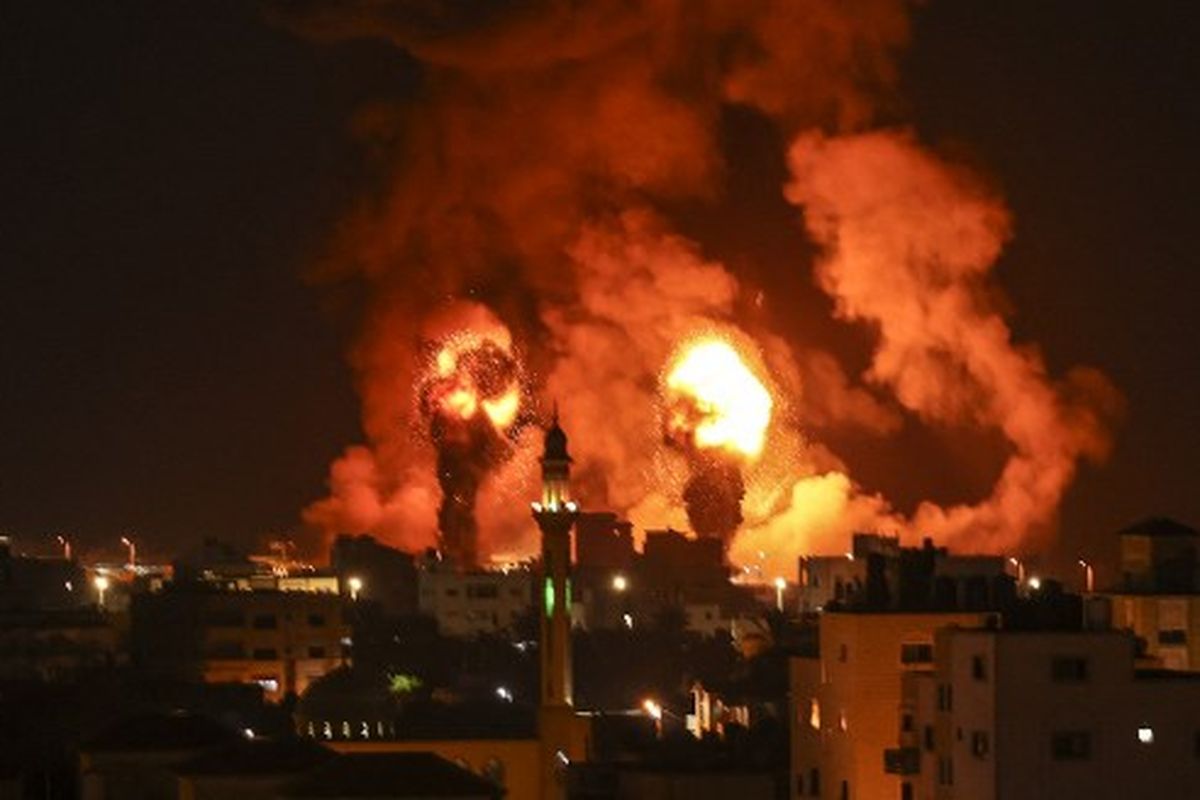 TOPSHOT - Kebakaran terlihat setelah serangan udara Israel di kota Gaza pada 16 Juli 2022. 