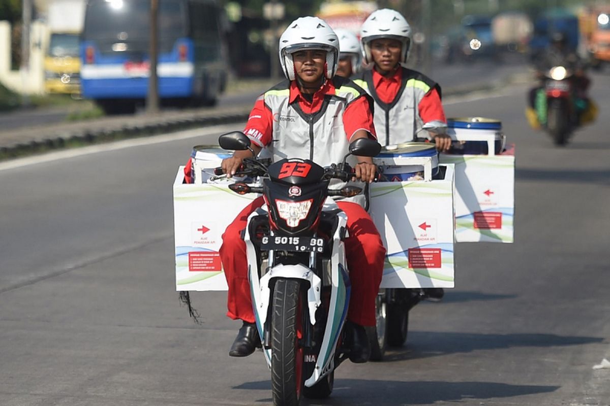 Petugas bermotor pengantar BBM dari KiosK Pertamax SPBU Muri berkeliling jalur pantura di Tegal, Jawa Tengah, Rabu (30/5). Pertamina menyiagakan 60 titik Kios BBM Kemasan atau KiosK Pertamax sebagai salah satu alternatif bagi pemudik untuk mendapatkan BBM selain di SPBU. ANTARA FOTO/Akbar Nugroho Gumay/aww/18.