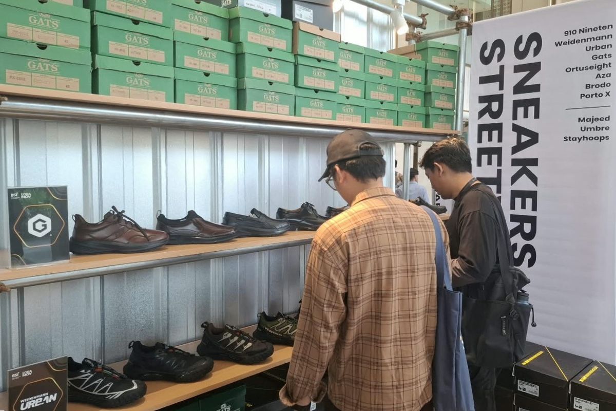 Dua orang pengunjung sedang memilih sepatu yang menarik perhatian mereka di salah satu booth LOKAMOV x BSI 2026. 
