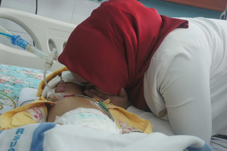 Bupati Cellica saat membisikkan kata-kata penyemangat kepada Calista, bayi 1 tahun yang diduga dianiaya pacar ibunya. 