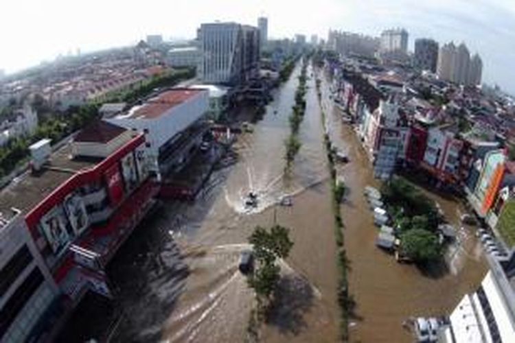 Kawasan Kelapa Gading, Jakarta Utara, terendam banjir, Selasa (10/2/2015). Jakarta menghadapi masalah penurunan muka tanah. Kondisi itu diperparah oleh semakin minimnya daerah resapan air yang diganti dengan hunian dan gedung-gedung pencakar langit.