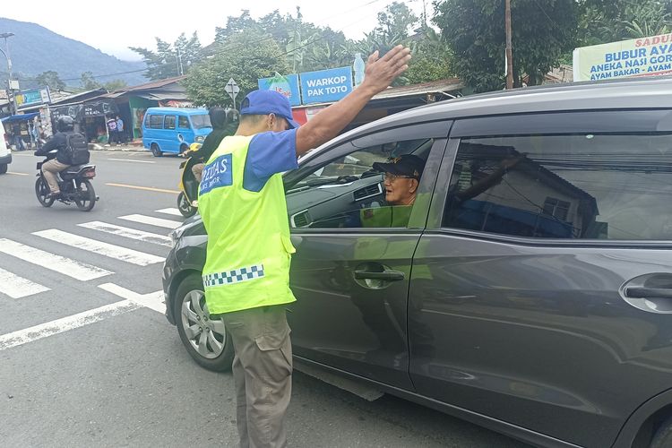 Supeltas saat memberikan arahan kepada pengendara mobil 