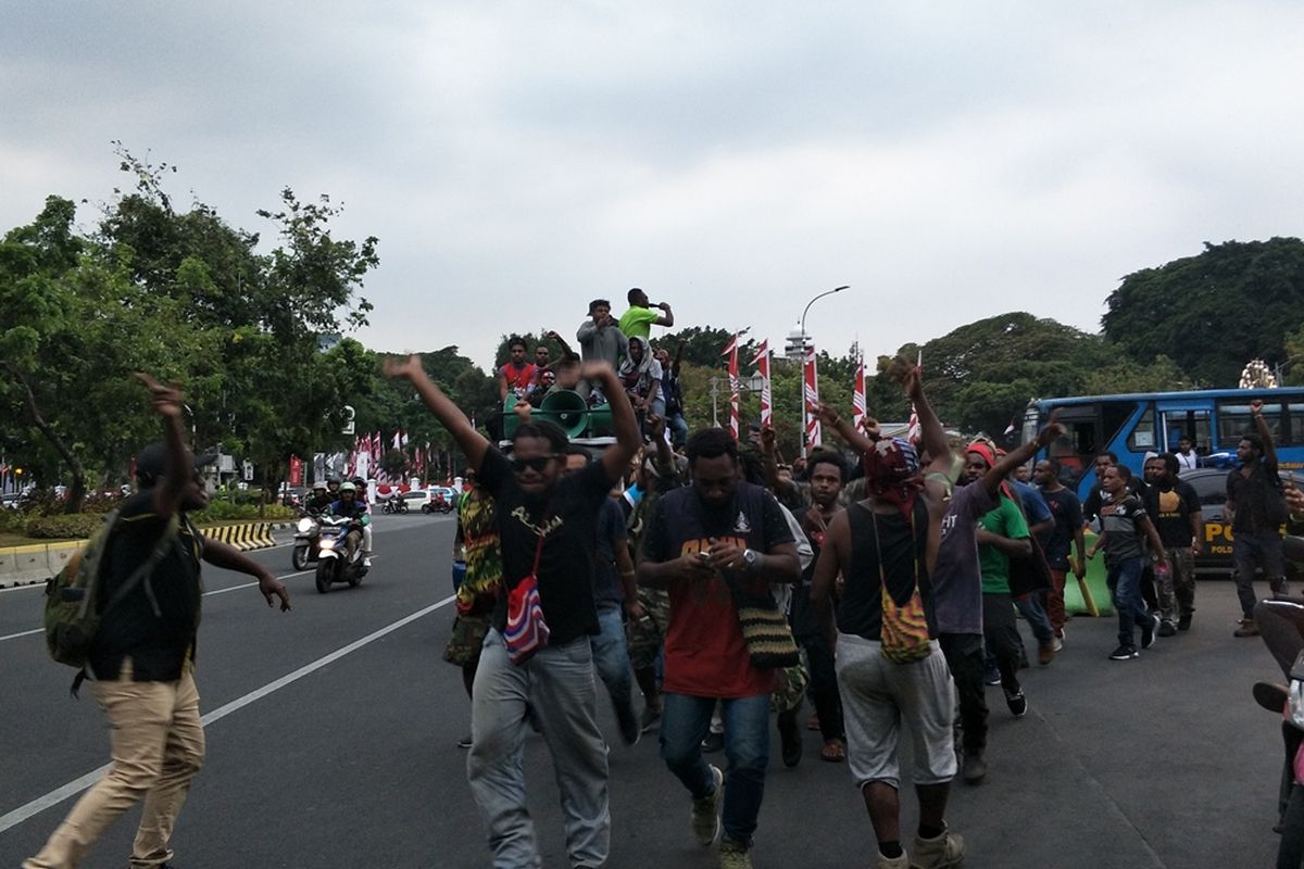 Mahasiswa Papua yang tergabung dalam Aliansi Mahasiswa Anti Rasisme, Kapitalisme, Kolonialisme, dan Militerisme, konvoi dari depan Istana Merdeka, Jalan Medan Merdeka Utara, menuju Kantor LBH Jakarta di Jalan Pangeran Diponegoro, Jakarta Pusat, Kamis (22/8/2019). Mereka mulanya konvoi dengan berlari tetapi kemudian naik sepeda motor, angkot, dan metromini.