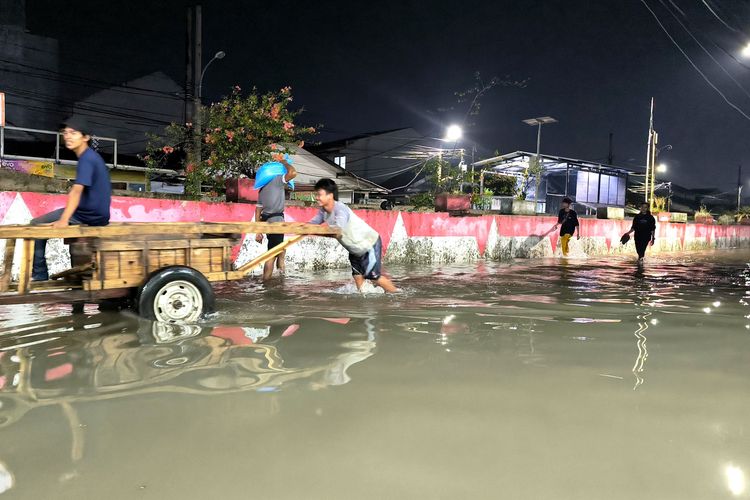 Momen warga Perumahan Taman Mangu Indah saat melintasi banjir setinggi kurang lebih 50 meter.