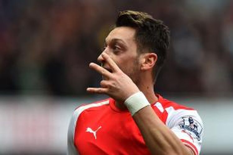 Gelandang Arsenal, Mesut Oezil merayakan gol kedua ke gawang Liverpool, Sabtu (4/4/2015)