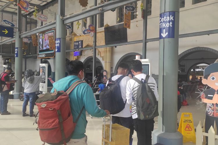 Agus Setiawan (kiri) saat mengantre di Stasiun Pasar Senen, Jakarta Pusat, untuk mencetak boarding pass pada Selasa (25/4/2023) 