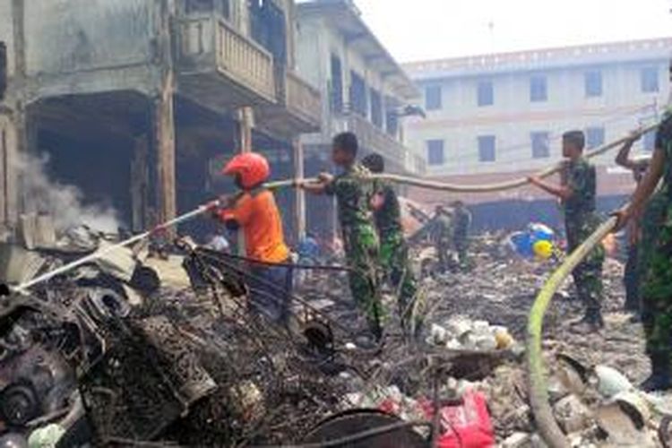 Sejumlah anggota TNI bersama petugas pemadam kebakaran bahu membahu membersihkan puing kebakaran di Pasar Tengah, Jalan Tanjungpura, Pontianak (22/8/2015)