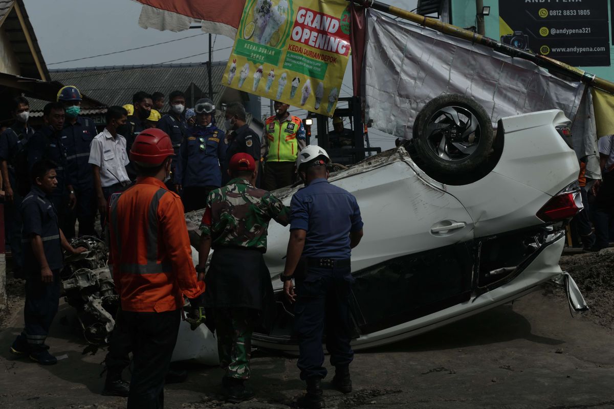 Petugas melakukan evakuasi mobil Mobilio dengan nomor polisi B 1563 NYZ yang tertabrak KRL Commuter Line di Depok, Jawa Barat, Rabu (20/4/2022). Akibat kejadian ini jadwal KRL dari Depok menuju Jakarta terganggu.