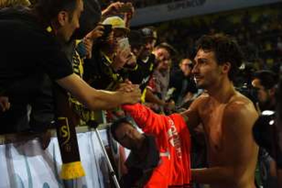 Bek Bayern Muenchen, Mats Hummels, menyalami suporter Borussia Dortmund usai laga Piala Super Jerman 2016 di Signal Iduna Park, pada Minggu (14/8/2016).
