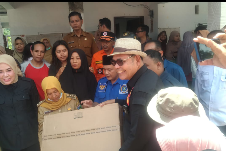 Bupati Solok Epyardi Asda (pakai kacamata) saat menyerahkan bantuan untuk korban bencana di Pesisir Selatan, Senin (18/3/2024).