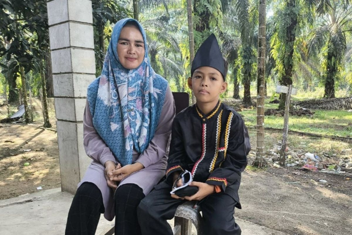 Anak Togak Luan Pacu Jalur Kuansing, Rayyan bersama ibunya, Rani, saat diwawancarai wartawan di rumahnya di Desa Pintu Lobang Kari, Kecamatan Kuantan Tengah, Kabupaten Kuansing, Riau, Jumat (4/7/2025).