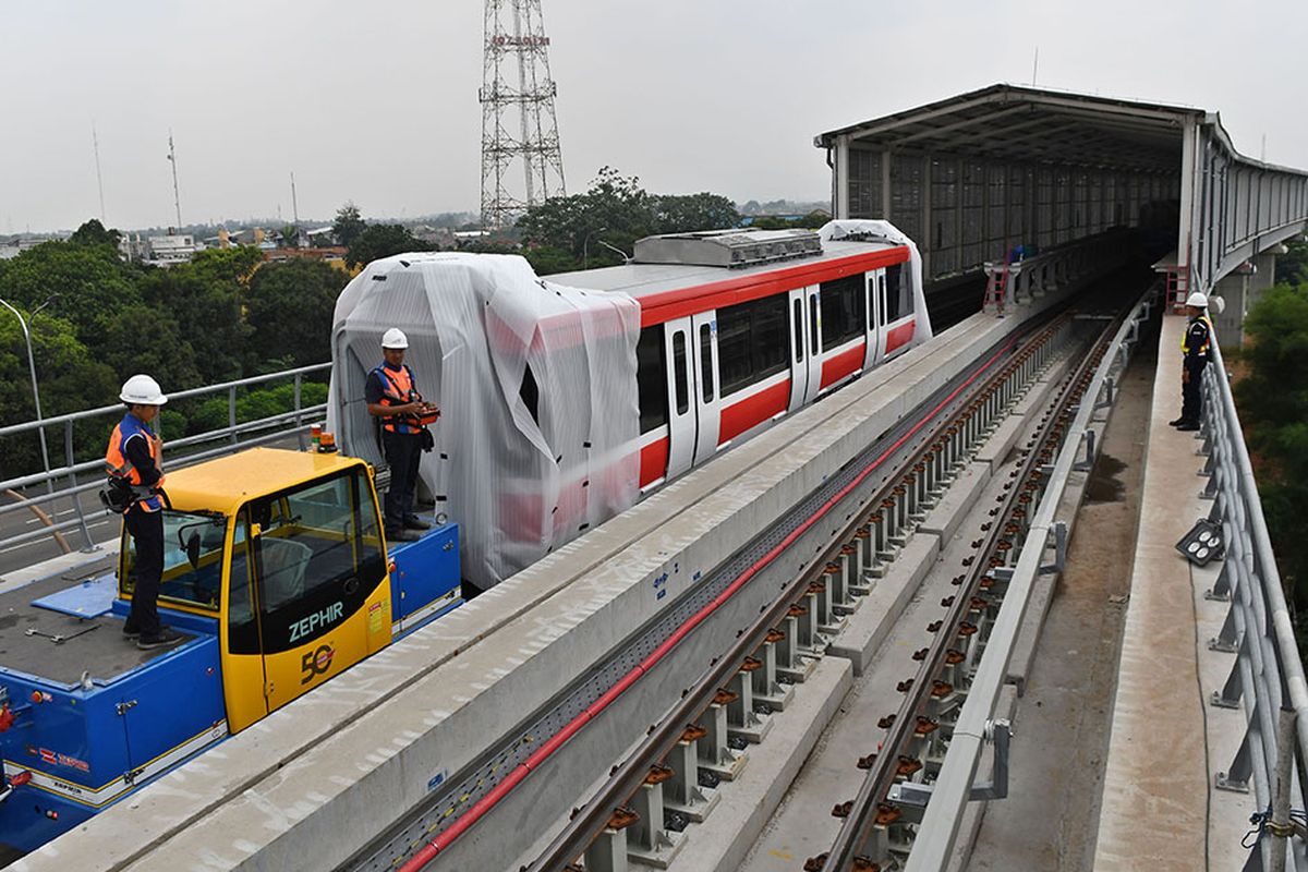 Sejumlah petugas mengoperasikan alat pendorong gerbong kereta 'light rail train' atau lintas rel terpadu (LRT) yang telah diangkat ke atas rel di Stasiun Harjamukti, Cimanggis, Kota Depok, Jawa Barat, Rabu (4/12/2019).