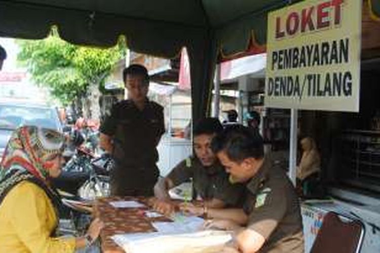 Warga membayar denda tilang pada petugas kejaksaan di Warung Kopi Lhoksukon Aceh Utara, Kamis (31/3/2016)