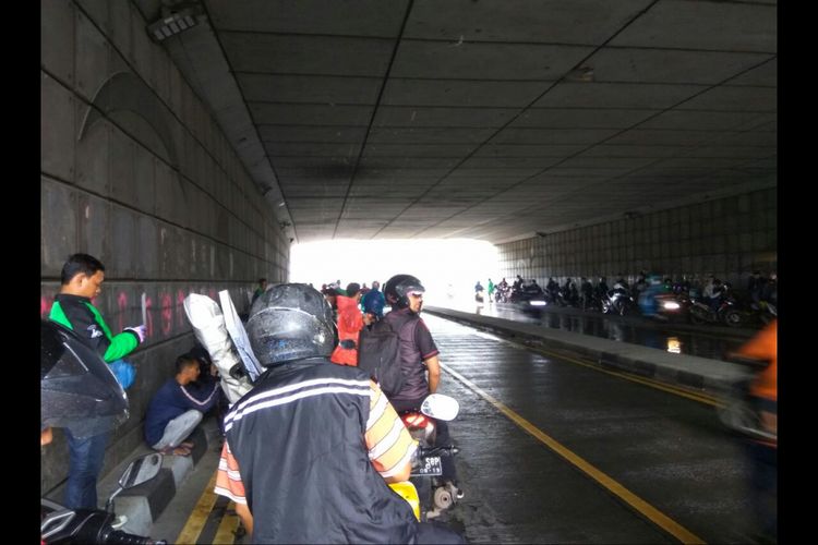 Para pengendara motor berteduh di kolong underpass Pasar Minggu Jakarta Selatan.