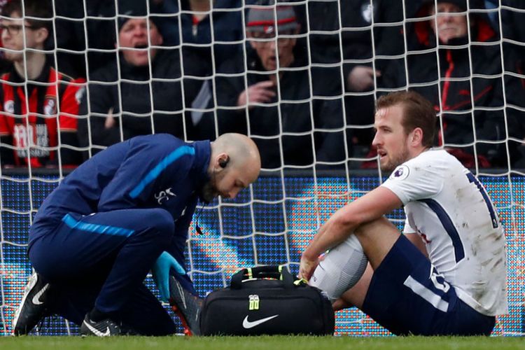 Penyerang Tottenham Hotspur, Harry Kane, mendapatkan perawatan seusai mendapatkan cedera pada laga versus Bournemouth di Stadion Vitality, Minggu (11/3/2018).