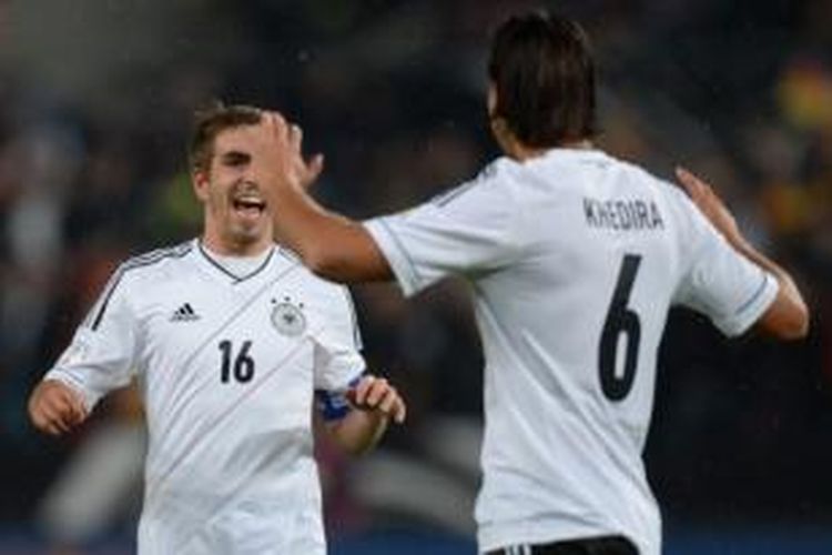 Kapten Philipp Lahm (kiri) merayakan gol yang dicetak rekannya, Sami Khedira (kanan), pada laga kontra Irlandia di RheinEnergieStadion, Koeln, Jumat (11/10/2013). Jerman menutup laga dengan kemenangan 3-0 atas Irlandia.