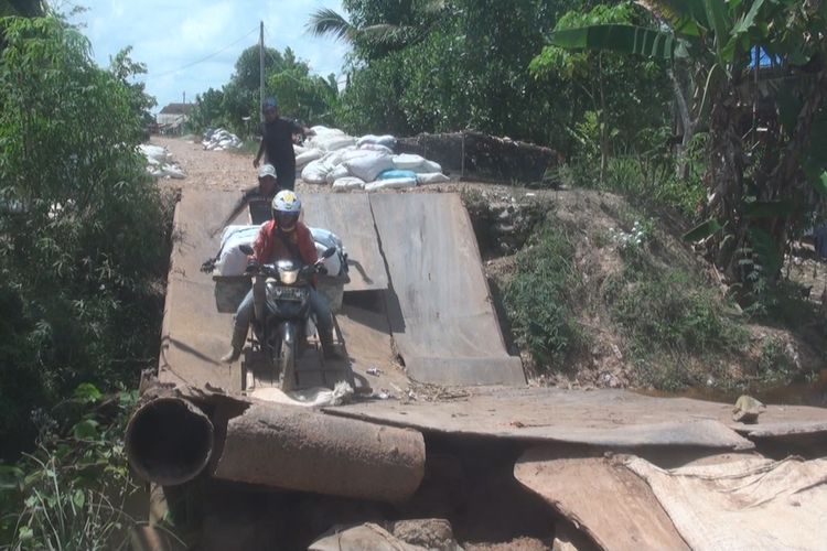 Pengendara sepeda motor nekad melintasi jembatan ambruk antara Desa Aur Standing dan Desa Mear Jaya Kecamatan Pemulutan.