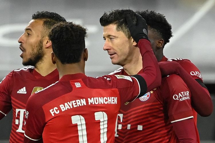 Striker Bayern Muenchen Robert Lewandowski (kedua dari kanan) mendapat selamat dari rekan usai mencetak gol dari titik penalti pada laga Bundesliga Dortmund vs Bayern di Dortmund, Jerman, pada 3 Desember 2021.