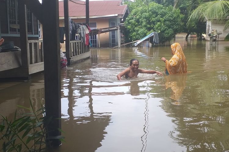 Sejumlah warga beraktivitas dengan melintasi banjir di Desa Buluh Cina, Kecamatan Siak Hulu, Kabupaten Kampar, Riau, Kamis (19/12/2019).