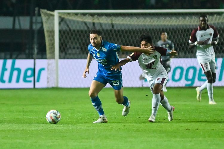 Gelandang Persib Marc Klok menggiring bola diganggu M Arfan pemain PSM Makassar, kedua pemain bertarung memenangkan duel lini tengah dalam laga pekan ke-21 Liga 1 2023-2024 antara Persib vs PSM, di Stadion Gelora Bandung Lautan Api (GBLA), Senin (4/12/2023).
