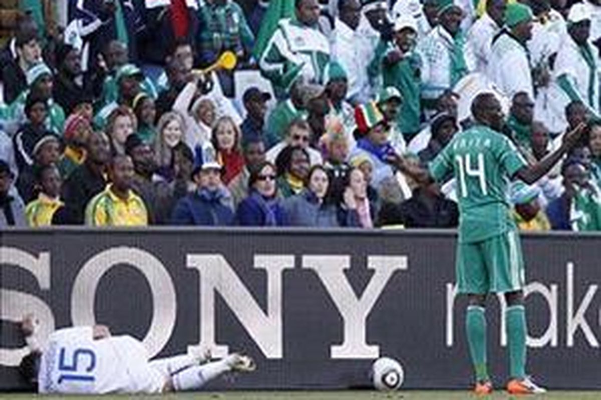 Bek Yunani, Vasilis Torosidis (kiri) terjatuh setelah ditendang gelandang Nigeria, Sani Kaita (kanan), dalam pertandingan penyisihan grup Piala Dunia 2010 Afrika Selatan, Kamis (17/6/2010).