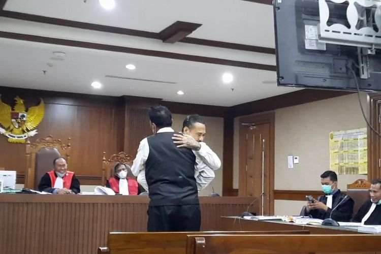 Jerinx SID memeluk ayahnya dalam sidang lanjutan perkara pengancaman terhadap Adam Deni di Pengadilan Negeri (PN) Jakarta Pusat, Rabu (9/2/2022). Pada persidangan tersebut, Jerinx meminta maaf kepada ayahnya yang menjadi saksi dalam kasus dengan Adam Deni. 
