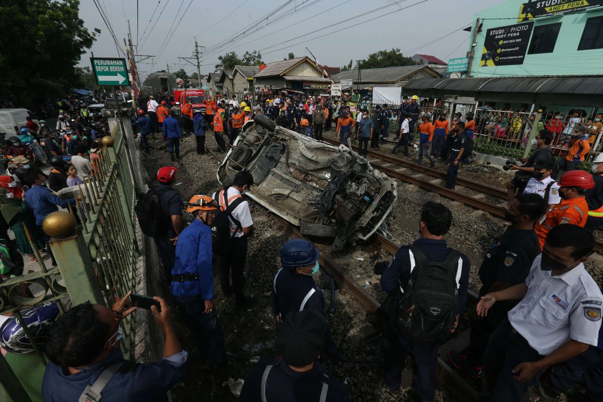 Petugas melakukan evakuasi mobil Mobilio dengan nomor polisi B 1563 NYZ yang tertabrak KRL Commuter Line di Depok, Jawa Barat, Rabu (20/4/2022). Akibat kejadian ini jadwal KRL dari Depok menuju Jakarta terganggu.