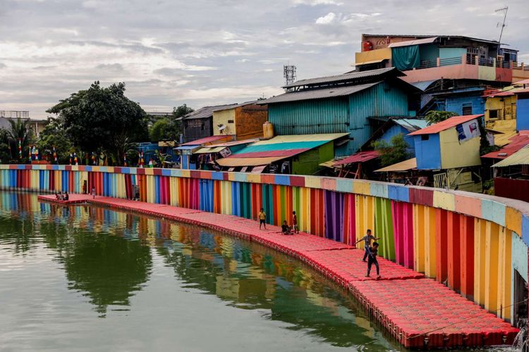 Anak-anak bermain di tepian Danau Sunter di wilayah Kelurahan Sunter Jaya, Kecamatan Tanjung Priok, Jakarta Utara, Minggu (25/3/2018). Pemprov DKI Jakarta melakukan program pengecatan kampung warna-warni di kawasan Danau Sunter untuk memperindah lingkungan sekaligus guna mengubah kesan kumuh kawasan tersebut.