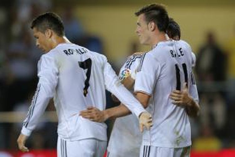 Pemain Real Madrid asal Wales, Gareth Bale (kanan), merayakan golnya ke gawang Villarreal dalam lanjutan La Liga di El Madrigal, Sabtu (14/9/2013). Bale, yang melakukan debutnya dengan El Real, mendapat sambutan dari Cristiano Ronaldo (kiri).