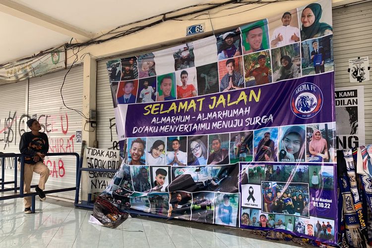 Seorang pria sedang melihat foto-foto Tragedi Kanjuruhan yang terpasang disekitar Gate 13 Stadion Kanjuruhan Kepanjen, Kabupaten Malang, Minggu (1/1/2023) siang.