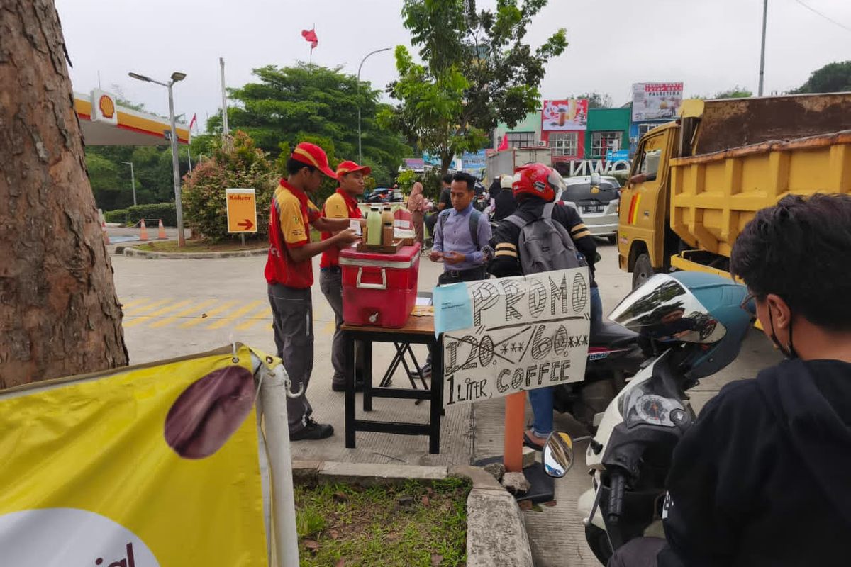 Petugas SPBU swasta saat tengah menjual produk makanan dan minuman di pinggir jalan.