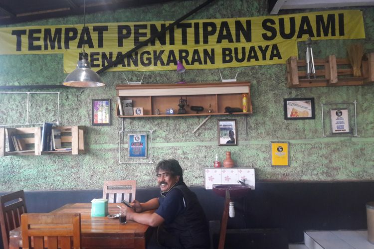 Salah seorang pengunjung setia Kedai Dukun sedang menikmati sajian kopi, Sabtu (16/6/2019)