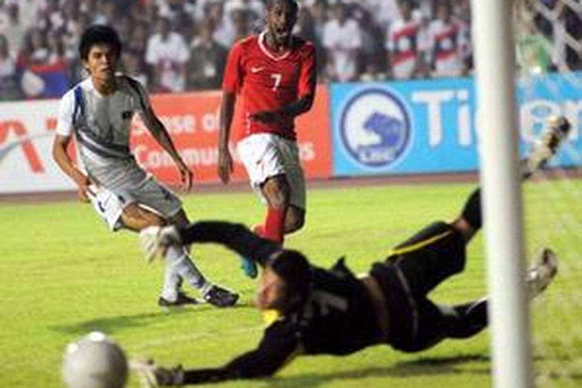 Striker Indonesia, Boaz Salossa, melepaskan tembakan yang masih meleset di sebelah kiri gawang Laos yang dikawal kiper Souvanpheng Phanthavong. Dalam pertandingan penyisihan Grup B SEA Games XXV Laos ini, Senin (7/12), Indonesia kalah 0-2 yang membuat posisi Boaz dkk sangat kritis karena terancam tersingkir di babak penyisihan grup ini.