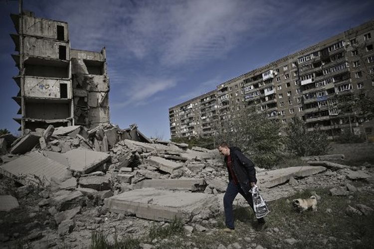Seorang pria berjalan melewati gedung yang rusak setelah serangan di Kramatorsk di wilayah Donbas, Ukraina timur, pada 25 Mei 2022. 