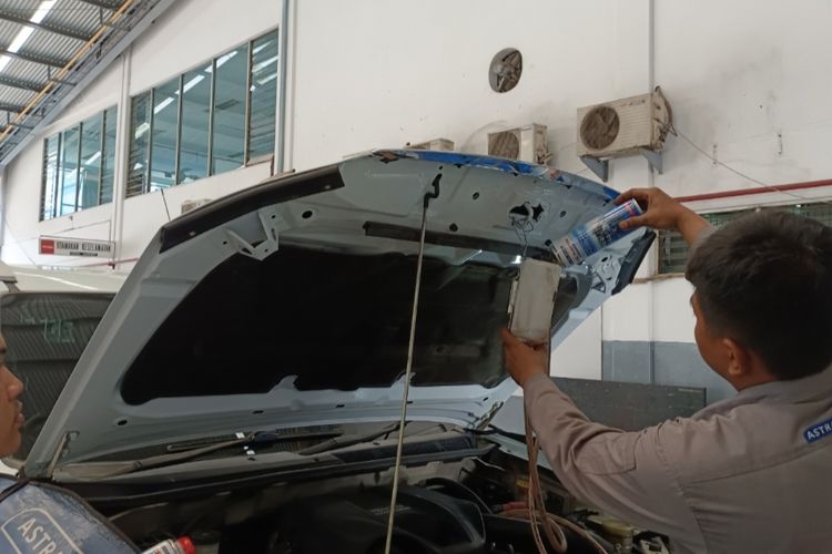 Mekanik bengkel resmi Astra Isuzu Majapahit, sedang melakukan perawatan injektor mesin.