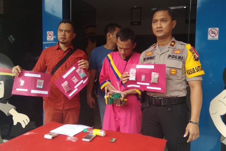 Tersangka Idham (36) ketika berada di Polsek Ilir Timur I Palembang, Sumatera Selatan, Rabu (19/12/2018). Idham ditangkap polisi lantaran membuat ekstasi palsu dengan menggunakan obat sakit kepala yang dicampur cat.