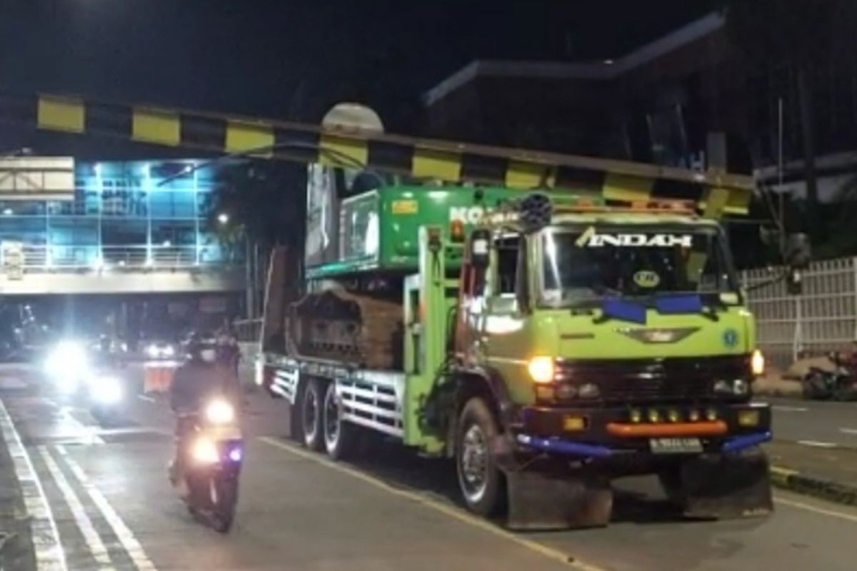 Truk yang sedang mengangkut crane tersangkut di portal pembatas ketinggian underpass Pondok Indah, Kebayoran Lama, Jakarta Selatan, Jumat (25/2/2022) dini hari.