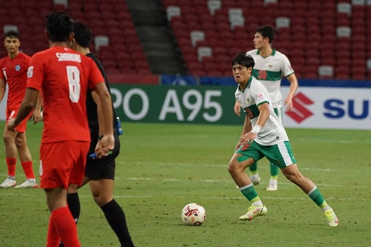 Pemain Indonesia Alfeandra Dewangga (kiri) menggiring bola pada laga leg pertama semifinal Piala AFF 2020 melawan Singapura yang berakhir 1-1 di National Stadium Singapore, Rabu (22/12/2021) malam WIB. 